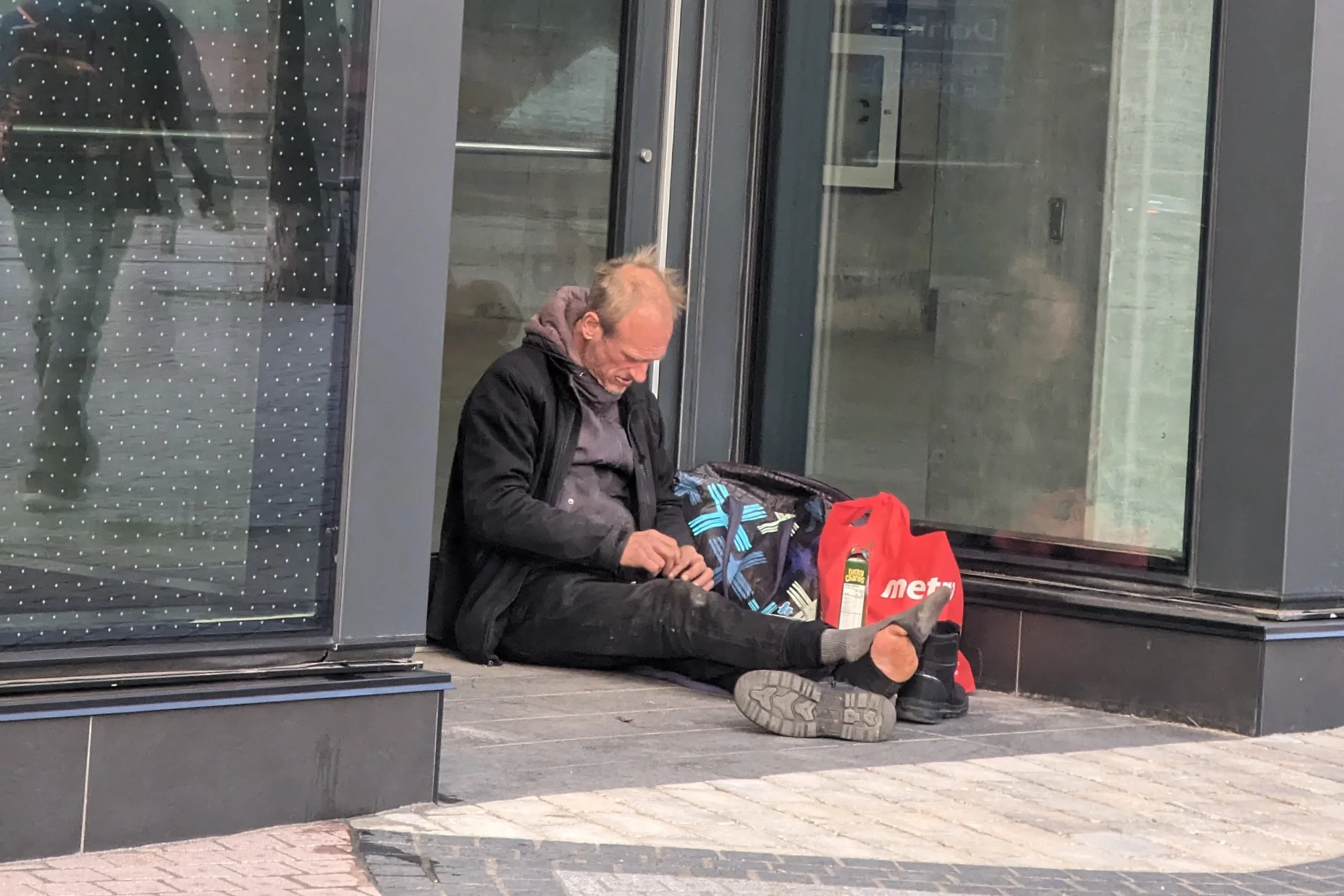 Homeless man resting in doorway in Toronto