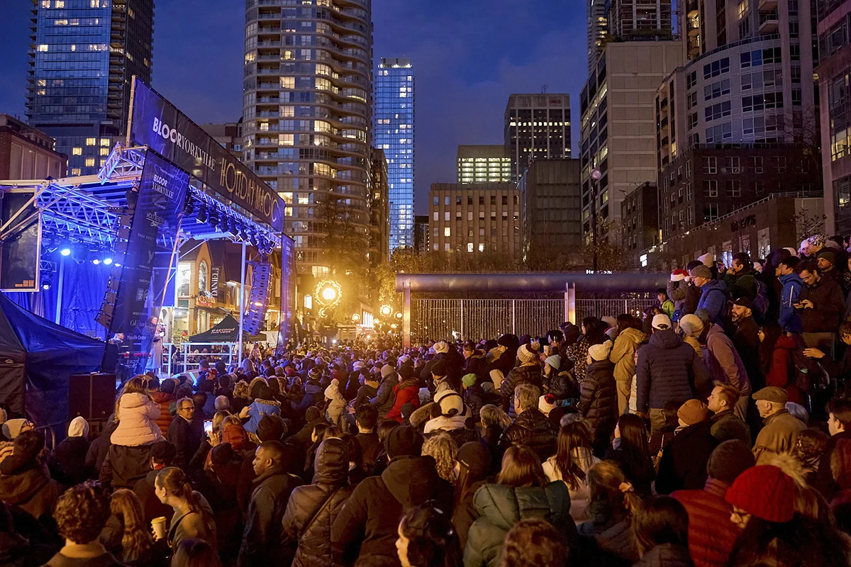 Crowd of people next to outdoor stage at twilight in the winter