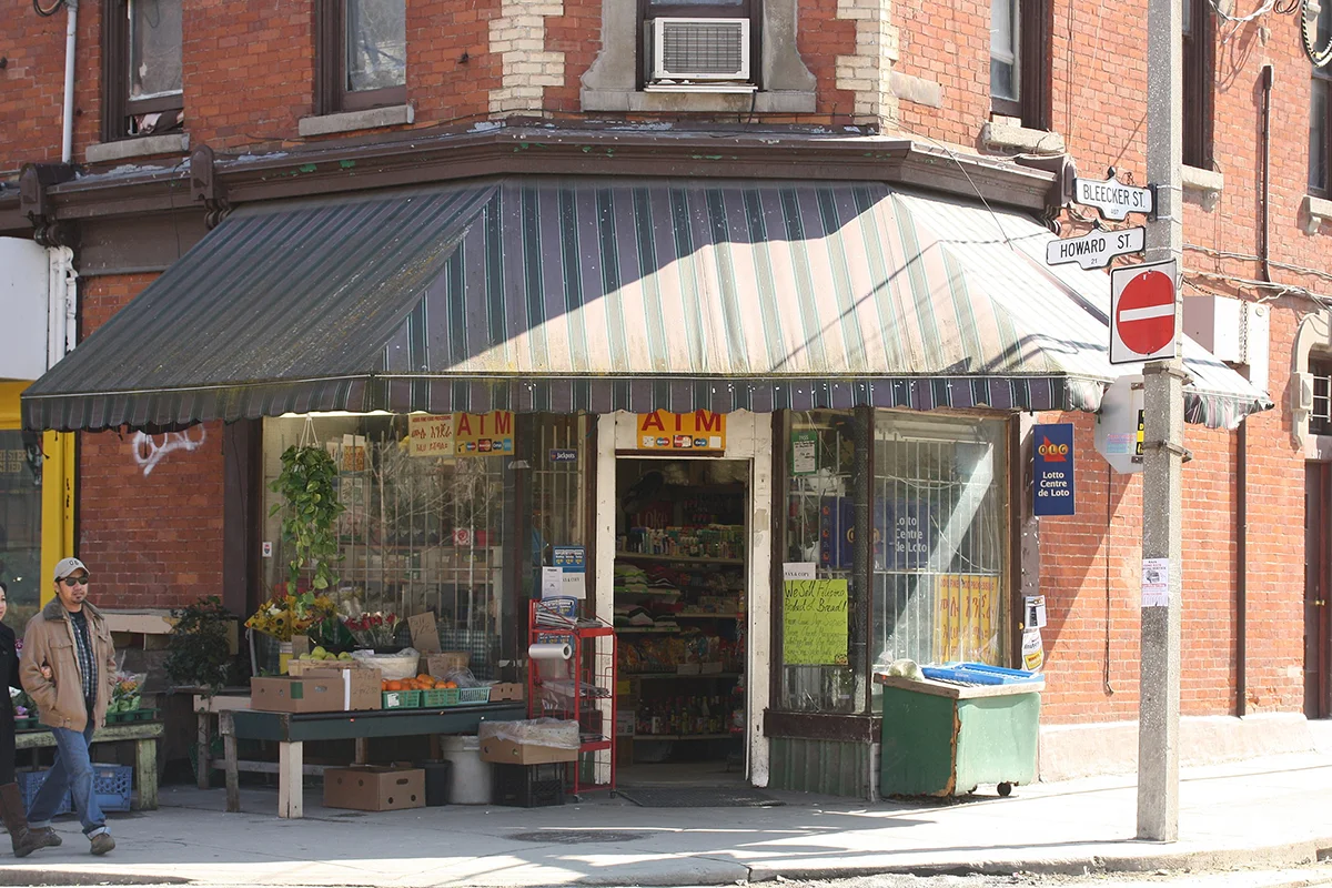 Entrance to neighbourhood convenience store in brick building at corner of two streets