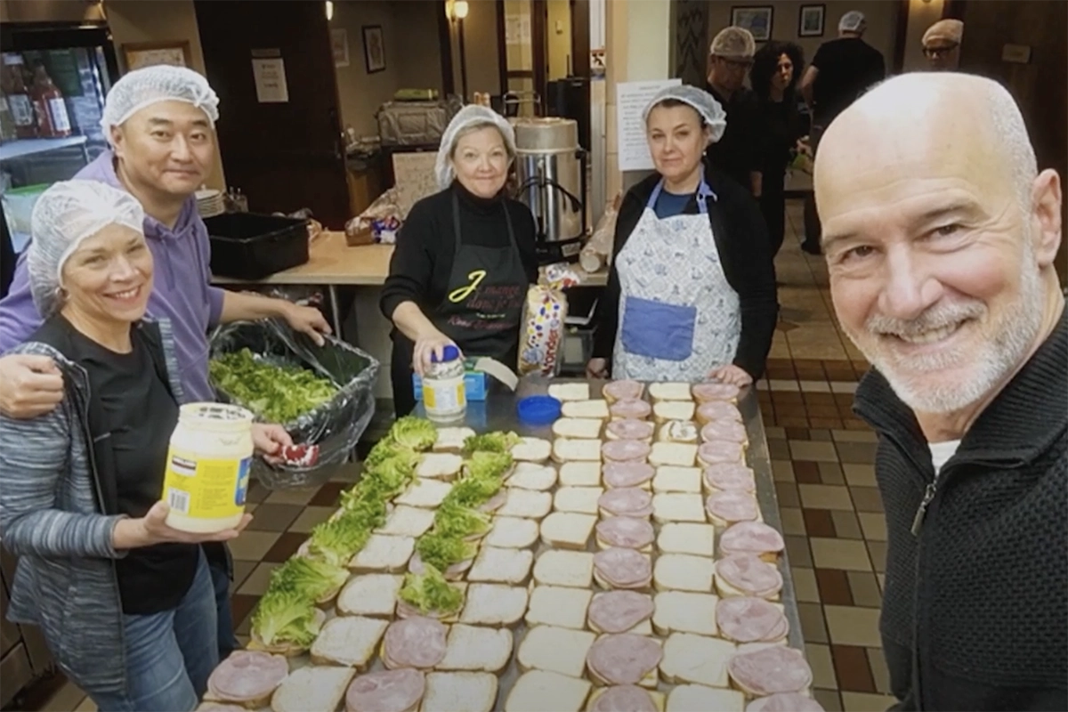 5 people around a table making sandwiches